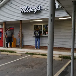 two men standing outside of a restaurant