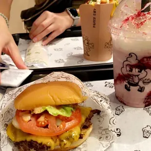 a hamburger and a drink on a tray