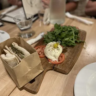 White truffle burrata board with prosciutto hidden by arugula on the other side-Delish!