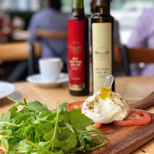 Burrata e White Truffle Oil - Fresh burrata cheese, arugula, fresh tomatoes and white truffle oil served with thin crispy Foccacia