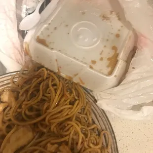 a bowl of noodles and a container of sauce
