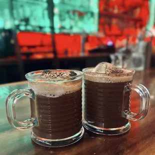 two mugs of hot chocolate on a table