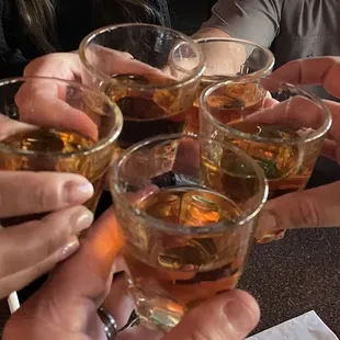 a group of people clinking glasses of alcohol