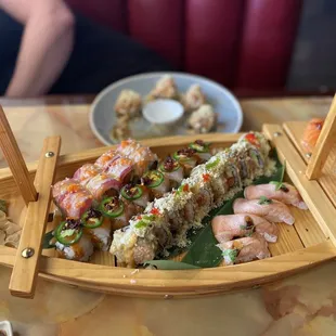 a wooden boat with sushi on it