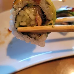 Tiny piece of eel in cucumber slices and undercooked rice