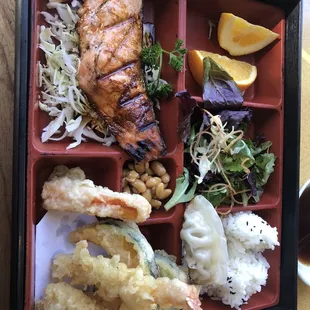 Bento box with teriyaki salmon and tempura shrimp and veggies