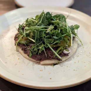 AREPA CON FRIJOLES NEGROS  cornmeal cake, black beans, pickled shallots, sugar snap peas