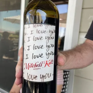 a hand holding a bottle of wine