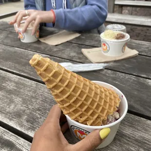 a hand holding a waffle cone