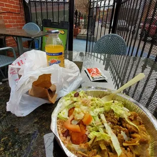 Goat curry with rice and beans, plantain, lettuce, and tomato.