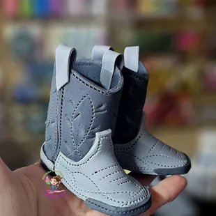 a hand holding a pair of boots