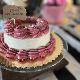 a three layer cake with pink frosting