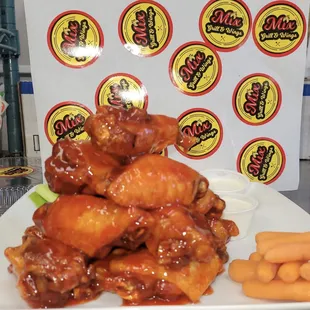 a plate of chicken wings and carrots