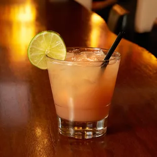 a cocktail with a lime slice on the rim