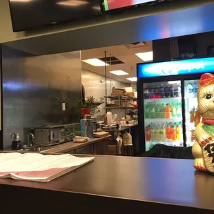 a cat figurine on a counter in a restaurant