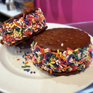 Creamy vanilla or chocolate ice cream between two wafer cookies, rolled in rainbow sprinkles