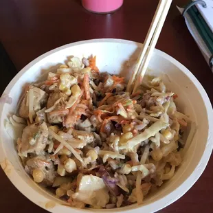 a bowl of food with chopsticks
