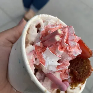 a hand holding a cup of ice cream