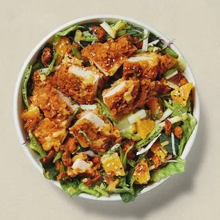 Mandarin salad: romaine hearts, kale, crispy chicken, cabbage, oranges, candied almonds, snow peas, jicima, miso ginger vinaigrette