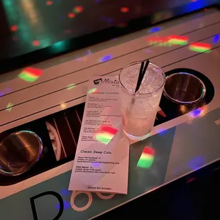 a drink and a menu on a table