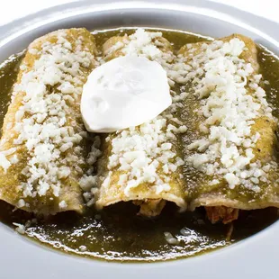 Pollo Enchiladas.
Marinated chicken and topped with grated cheese and sour cream. Served with cilantro-lime rice and refried pinto beans.