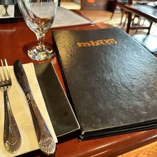 a menu, fork and knife on a table