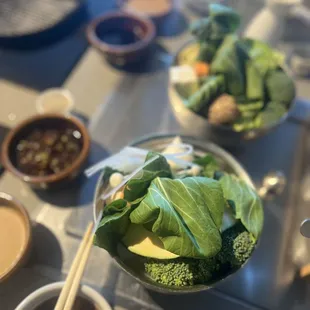 a bowl of broccoli with chopsticks