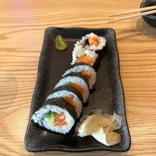 a plate of sushi with chopsticks