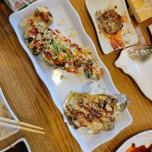 Remnants of a volcano row on the top corner, spicy tuna tempura roll on left, Japanese lasagna roll on right!