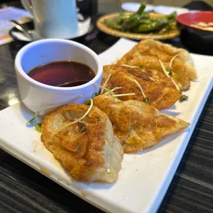 a plate of dumplings with dipping sauce