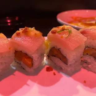 a plate of sushi rolls on a pink plate