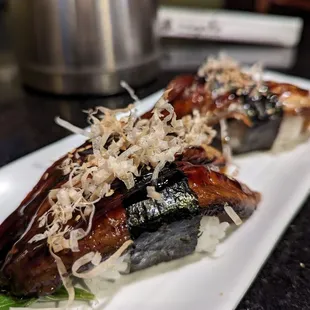 two pieces of sushi on a white plate