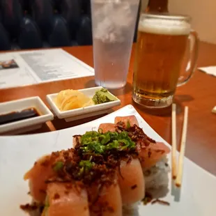 a glass of beer and a plate of sushi