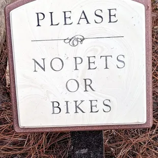 This sign is at both entrances that pets and bikes are not allowed in the garden.  Photo taken March 25, 2023.