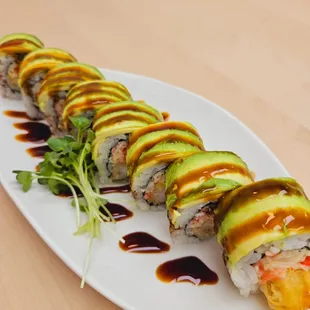 a sushi roll with avocado and sauce