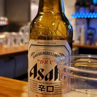 a beer bottle and a glass on a bar