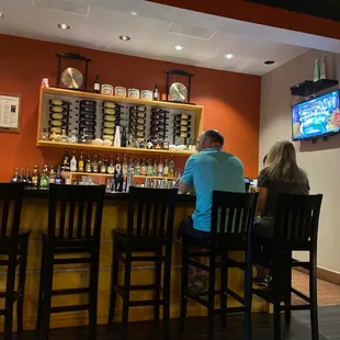 a man and a woman sitting at a bar