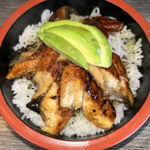 a bowl of rice with chicken and avocado