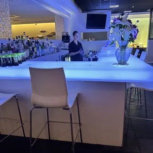 a bar with a vase of flowers on the counter