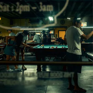 people playing pool in a pool hall