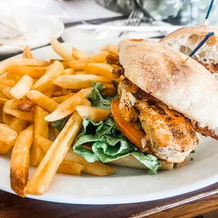 Club sandwich on ciabatta bread and a side of fries.