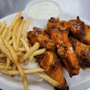 a plate of chicken wings and french fries