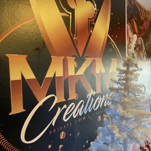 a christmas tree in front of a large sign