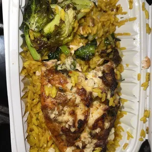 Half eaten lol .. chefs special salmon with shrimp and crab meat on top with yellow rice and Brussels
