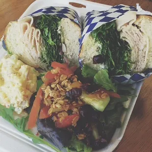 Turkey sandwich with salad and potato salad and it comes with a side of soup.