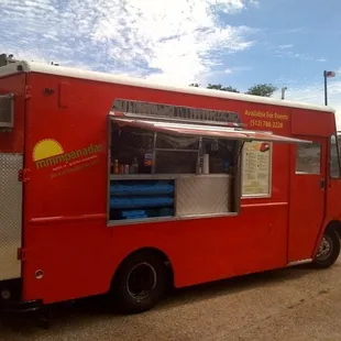 a red food truck parked in a parking lot