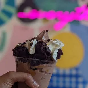 a hand holding a cup of ice cream