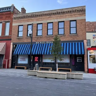 a brick building with a blue and white awning