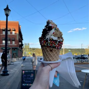 a person holding a cone of ice cream