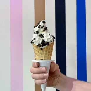 a hand holding an ice cream cone